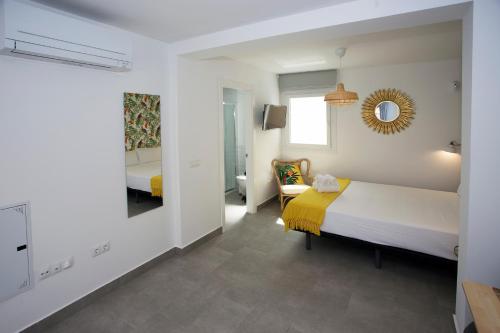 a bedroom with a bed and a mirror at MONKÓ - KIWI & TROPYCAL APARTMENT o in Torremolinos