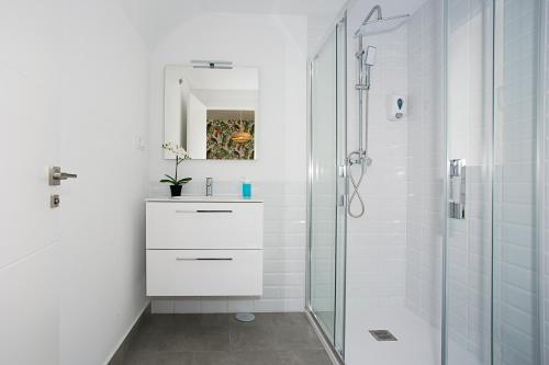 a white bathroom with a sink and a shower at MONKÓ - KIWI & TROPYCAL APARTMENT o in Torremolinos