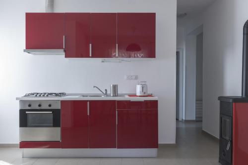 a kitchen with red cabinets and a sink at Apartment Karin in Medulin