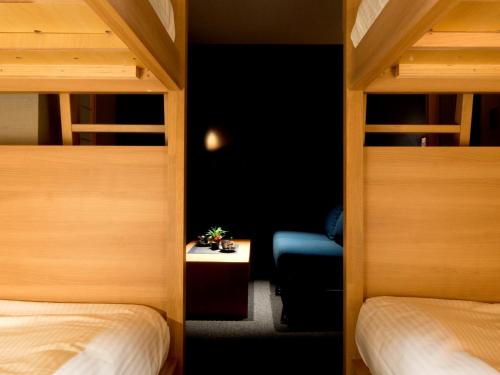 Zimmer mit 2 Etagenbetten und einem blauen Stuhl in der Unterkunft ALPHABED INN Takamatsuekimae 303 / Vacation STAY 36564 in Takamatsu