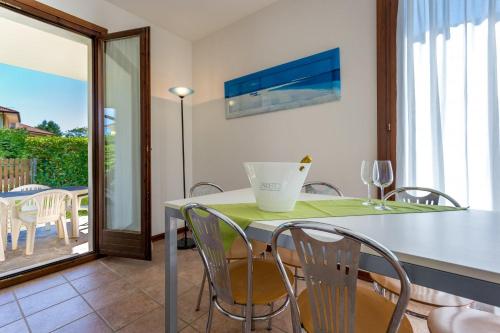 a dining room with a table and chairs and a balcony at Villa V4 bi-trifamiliare in Isola Albarella
