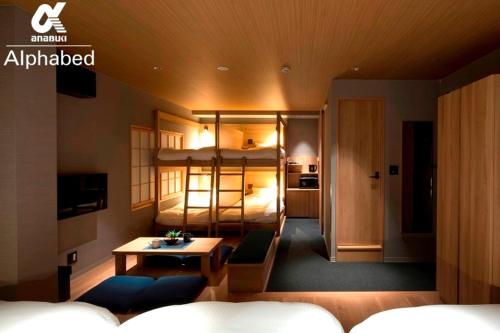 - une chambre avec des lits superposés et une table dans l'établissement ALPHABED INN Takamatsuekimae 202 / Vacation STAY 36555, à Takamatsu