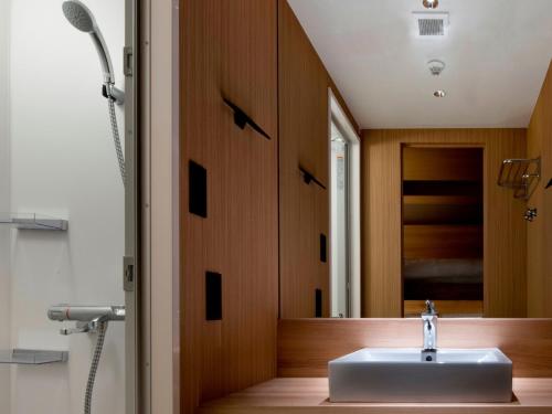 La salle de bains est pourvue d'un lavabo et d'un miroir. dans l'établissement ALPHABED INN Takamatsuekimae 202 / Vacation STAY 36555, à Takamatsu