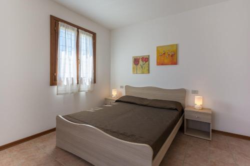 1 dormitorio con 1 cama grande y 2 mesitas de noche en Villa V4 bi-trifamiliare, en Isola Albarella