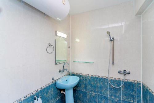a bathroom with a blue sink and a shower at Хотел Лагуна in Chernomorets