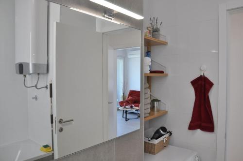 a bathroom with a large mirror and a sink at Apartment Carmen, Žnjan, Split in Split