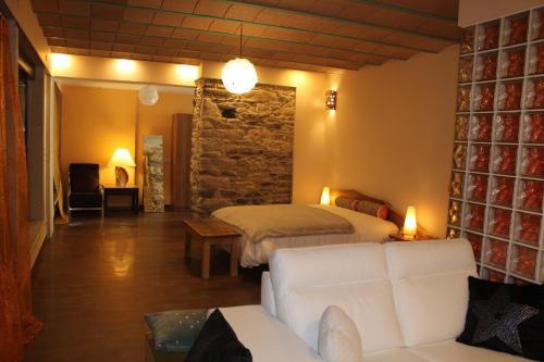 - une chambre avec un lit et un canapé dans l'établissement XARDÍN DE ESTRELAS ***, à Sarria