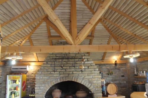 a stone fireplace in a kitchen with wooden ceilings at Vila Boska Palic in Palić