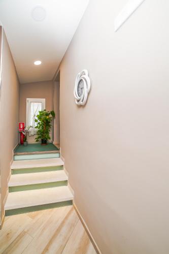 a hallway with stairs and a wall with a plant at Tramonti di Sole in Tramonti