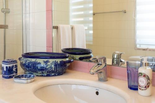 a bathroom sink with blue and white dishes on it at Geronimo Guest House Belém in Lisbon