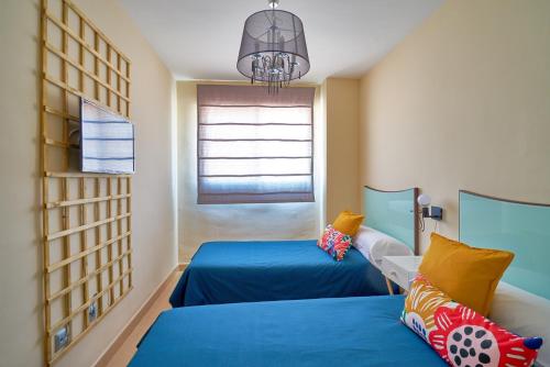 a bedroom with two beds and a window at La Macarena Airport in Málaga