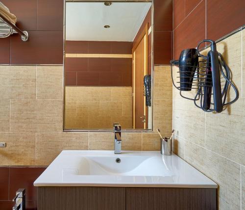 W łazience znajduje się umywalka i lustro. w obiekcie La Macarena Airport w Maladze