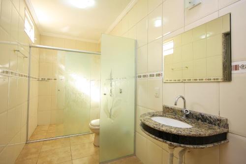 uma casa de banho com um lavatório e um chuveiro em Motel Vison (Próximo GRU Aeroporto) em Guarulhos