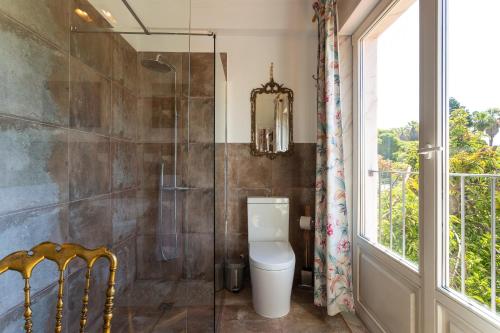 a bathroom with a toilet and a glass shower at Geronimo Guest House Belém in Lisbon