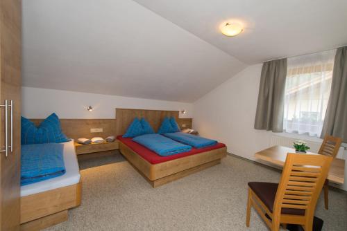 1 Schlafzimmer mit 2 Betten und blauen Kissen in der Unterkunft Appartements Romantika & Appartement Barbara in Wagrain