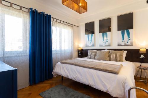 a bedroom with a large bed with blue curtains at Geronimo Guest House Belém in Lisbon