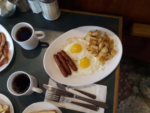 a plate of food with eggs and potatoes and coffee at Fuller Lake Chemainus Motel in Chemainus