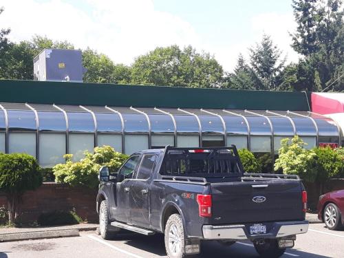 a black pick up truck parked in a parking lot at Fuller Lake Chemainus Motel in Chemainus