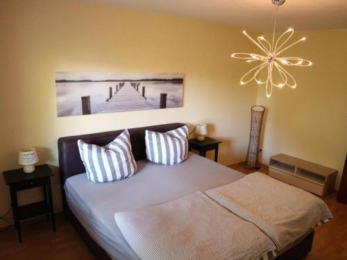 a bedroom with a bed with two pillows and a chandelier at Komplette Unterkunft - Troisdorf - Rotter See 60m² in Troisdorf