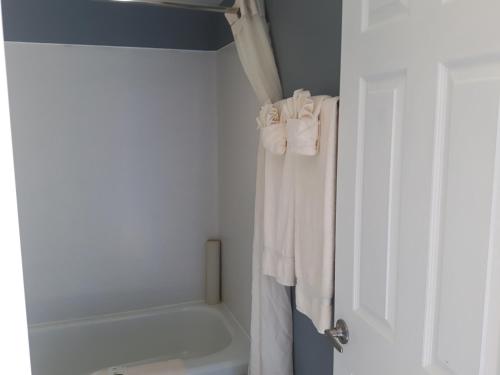 a bathroom with white towels and a bath tub at Fuller Lake Chemainus Motel in Chemainus