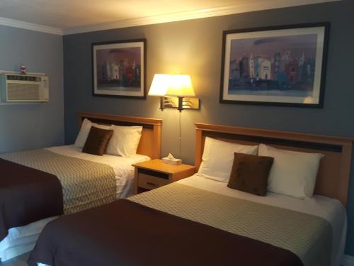 a hotel room with two beds and a lamp at Fuller Lake Chemainus Motel in Chemainus