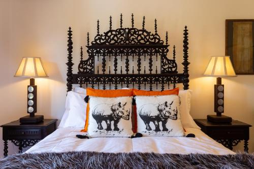 a bed with an ornate headboard and two lamps at Geronimo Guest House Belém in Lisbon