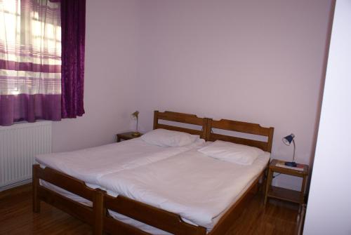 a bedroom with a bed with white sheets and a window at Karin's B&B in Sisian