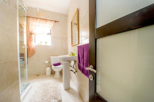 a bathroom with a sink and a toilet at aloha apartments in Marsalforn