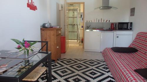 ein Wohnzimmer mit einem Sofa und einem Tisch sowie eine Küche in der Unterkunft La Polaris in Angerville-lʼOrcher