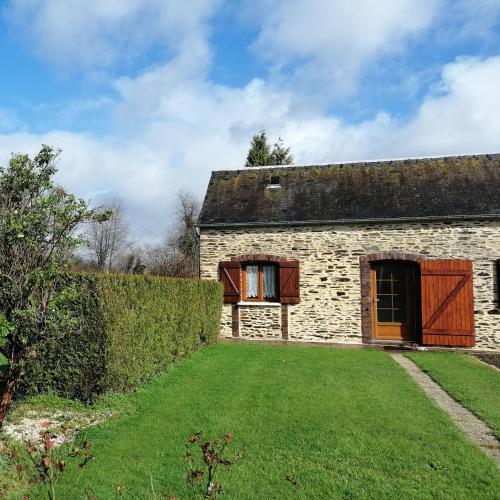una vecchia casa in pietra con un cortile verde di Maison MooMoons a Vaubadon
