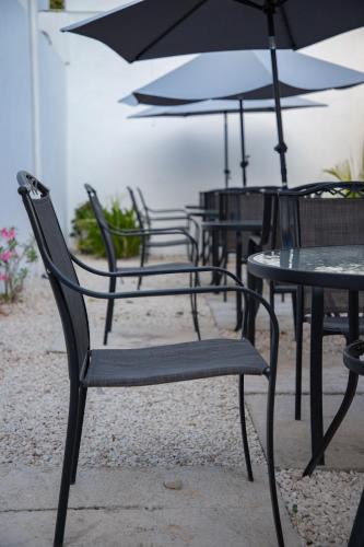 a group of chairs and tables with an umbrella at Margarett Hotel in Valladolid