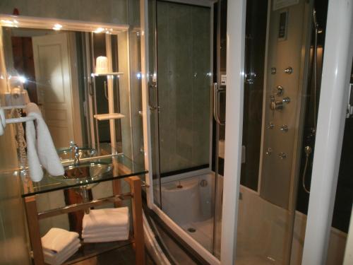 a bathroom with a glass shower and a sink at Hotel Restaurant Lancheton in Saint-Julien-Mont-denis