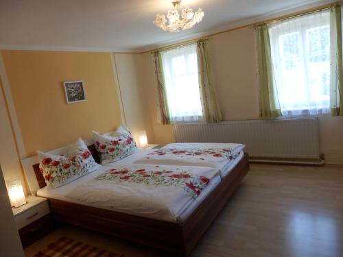 a bedroom with a bed with red flowers on it at Ferienwohnungen Strohmayerhof in Rastenfeld