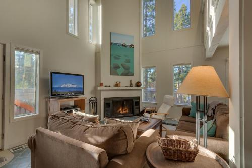 Una sala de estar con un sofá y una chimenea. en Sunny Daze at Dollar Point by Tahoe Getaways - Tahoe Classic w Open Floor Plan, Wood Fireplace, Close to Lake!, en Tahoe City