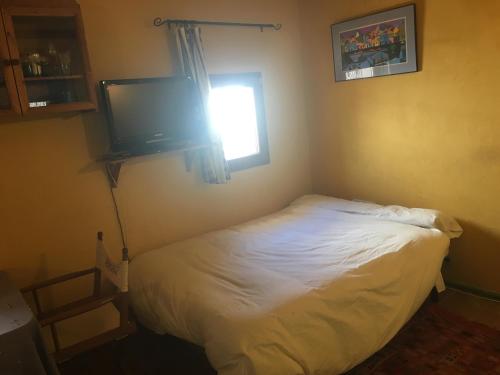 Schlafzimmer mit einem Bett und einem Flachbild-TV in der Unterkunft Estudio El Zoco in Granada