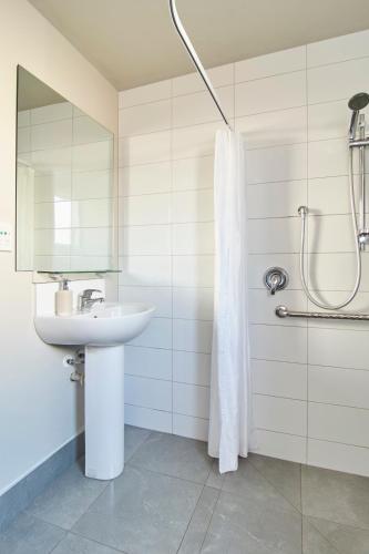 a white bathroom with a sink and a shower at Orari Boutique Hotel in Christchurch