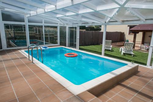 uma piscina com uma pérgola e uma piscina exterior em Casa Robledo em Palazuelos de Eresma