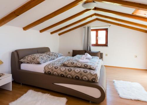 een slaapkamer met een bed in een kamer met houten plafonds bij Apartments Alma in Crveni Vrh