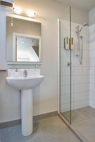 a bathroom with a sink and a glass shower at Orari Boutique Hotel in Christchurch