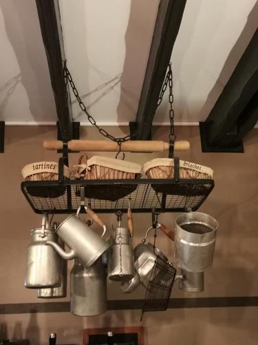 un lustre suspendu au plafond avec des casseroles et des poêles dans l'établissement Auberge Saint-Jean, à Villequier-Aumont