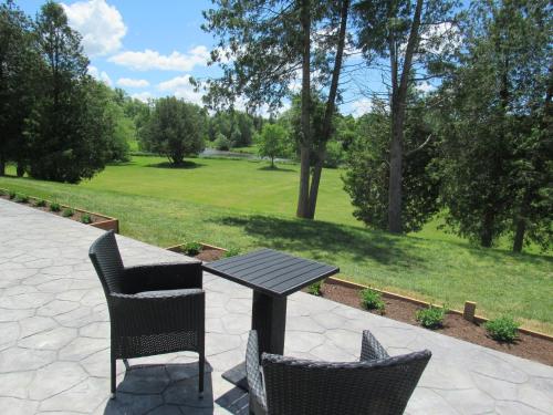 a picnic table and chairs with a view of a park at Inner Joy Getaways in Elora