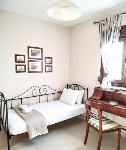 a bedroom with a bed with a piano and a chair at Villa Elia in Sfakia