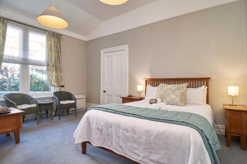 a bedroom with a bed and a desk and a window at Orari Boutique Hotel in Christchurch