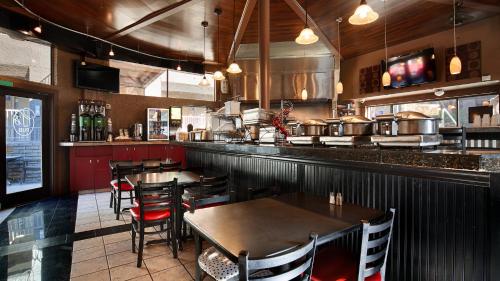 Best Western Yuma Mall Hotel & Suites في يوما: مطعم به طاولات وكراسي وبار