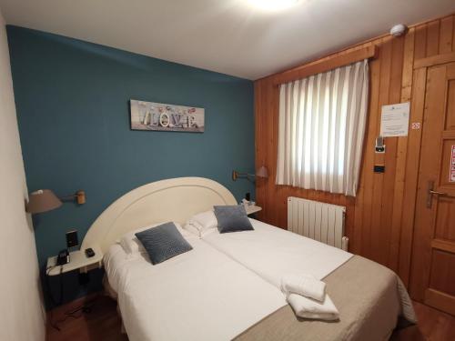 維爾奧蒙特的住宿－Auberge Saint-Jean，卧室配有白色大床和蓝色的墙壁