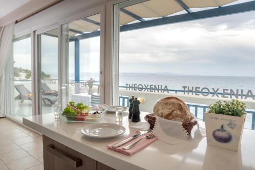 a kitchen with a table with a view of the ocean at Theoxenia Chios Apartments in Paralia Agias Foteinis