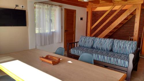 a living room with a table and a couch at Cabañas Cuatro Estaciones in Lago Puelo