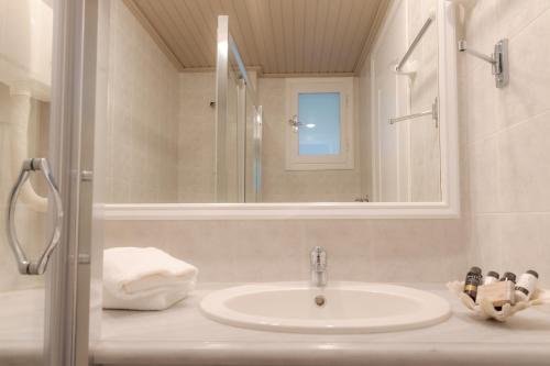 uma casa de banho com um lavatório e um espelho em Theoxenia Chios Apartments em Paralia Agias Foteinis