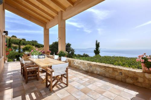 un patio al aire libre con mesa de madera y sillas en Villa Vollard en Rodhiá