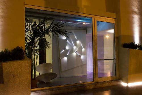 a room with a window with a chair and a plant at President Hotel Palermo in Palermo
